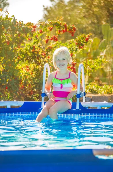 Lachende gezond meisje zit in zwembad — Stockfoto