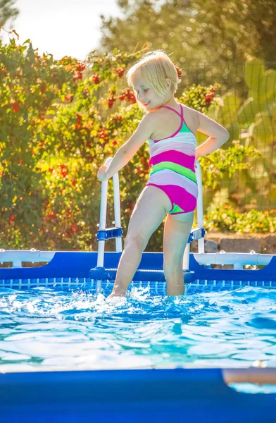 Lachende gezond meisje in kleurrijke zwembroek in zwembad — Stockfoto
