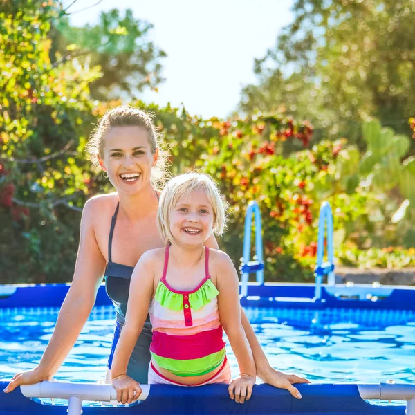 Mãe ativa feliz e filha de pé na piscina — Fotografia de Stock