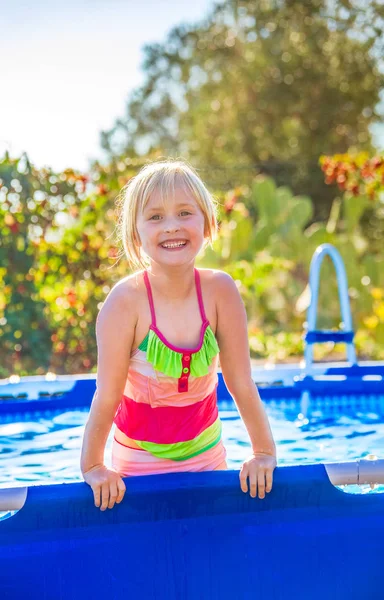 Sonriente niño activo en traje de baño jugando en la piscina —  Fotos de Stock