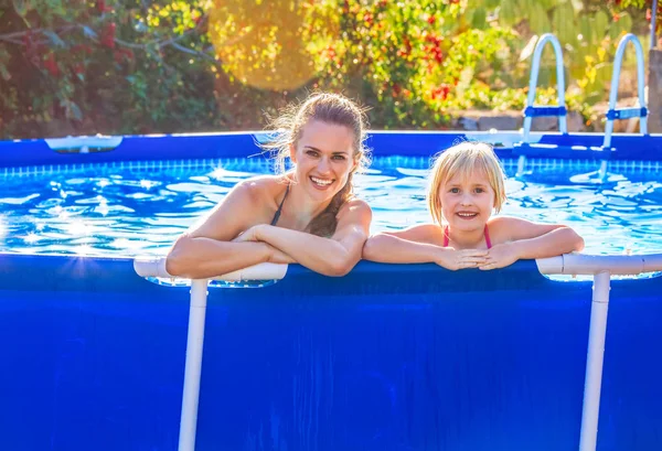 Mãe ativa feliz e criança na piscina relaxante — Fotografia de Stock