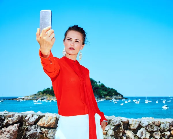 Turist kvinna i Donostia, Spanien med smartphone tar selfie — Stockfoto