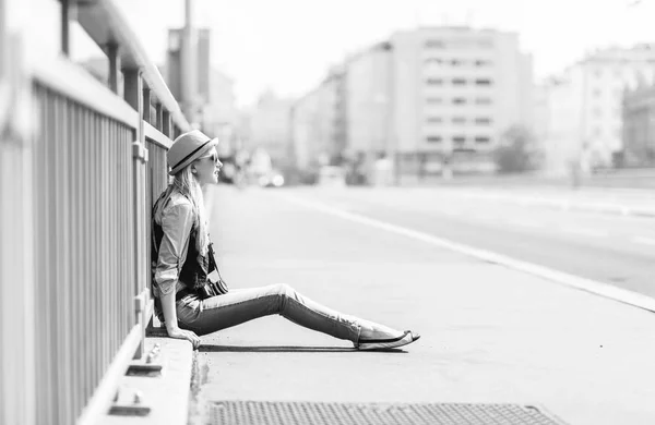Хипстерская девушка сидит на городской улице — стоковое фото