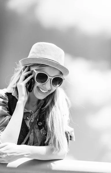 Улыбающаяся хипстерша разговаривает по мобильному телефону с небом — стоковое фото