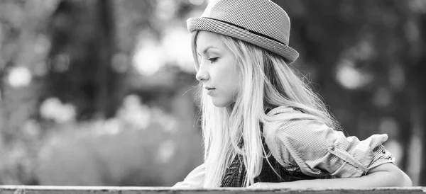 Chica hipster pensativo sentado en el banco en el parque —  Fotos de Stock