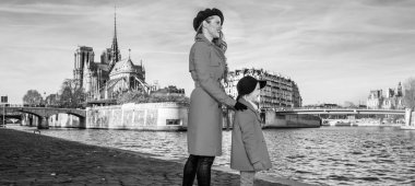 Paris'te parlak. Son moda anne ve mesafe içine bakarak kızı gezginler ile üzerinde dolgu Paris, Fransa'da kırmızı renk paltolar tam uzunlukta portre