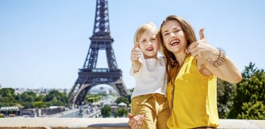 Eğleniyor Paris dünya ünlü dönüm noktası yakın zaman. Mutlu anne ve Eyfel Kulesi önünde başparmak gösterilmesini çocuk portresi