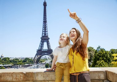 Eğleniyor Paris dünya ünlü dönüm noktası yakın zaman. Mutlu anne ve Eyfel Kulesi karşı bir şey üzerinde işaret eden çocuk portresi