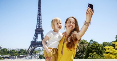 Eğleniyor Paris dünya ünlü dönüm noktası yakın zaman. Paris, Fransa için dijital fotoğraf makinesi ile selfie alarak gülümseyen anne ve çocuk turist