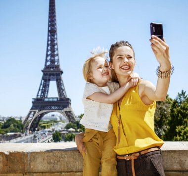 Eğleniyor Paris dünya ünlü dönüm noktası yakın zaman. mutlu anne ve kızı gezginler Eyfel Kulesi karşı dijital fotoğraf makinesi ile selfie alarak