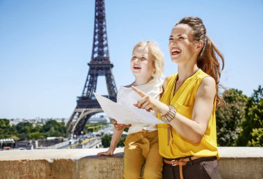 Eğleniyor Paris dünya ünlü dönüm noktası yakın zaman. harita tutarak ve Paris, Fransa'da işaret gülümseyen anne ve çocuk turist