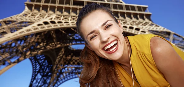 Touristy, without doubt, but yet so fun. Portrait of happy young woman in the front of Eiffel tower in Paris, France