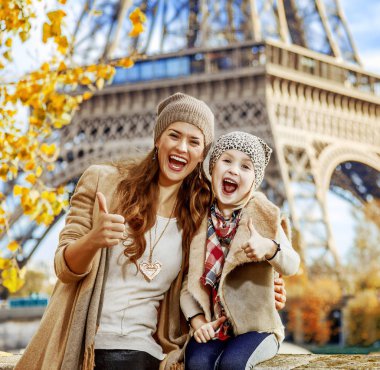 Başparmak gösterilmesini mutlu anne ve çocuk gezginler setin yakınındaki Eyfel Kulesi Paris, Fransa'da portresi