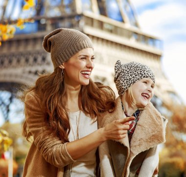 Bir şeye işaret eden setin Paris, Fransa'da anne ve kızı turistlere gülümseyen portresi