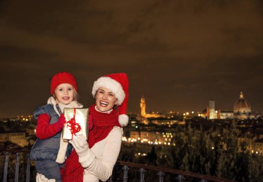 Gezi Floransa'da Noel anda ilham dolu. Genç anne ve kızı gezginler Noel şapka Noel hediyesi kutu Floransa panoramik ön tarafında ile gülümseyen portresi