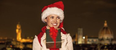 Gezi Floransa'da Noel anda ilham dolu. Genç kadında mutlu Noel hediyesi kutusu kenara seyir ile Noel şapka Floransa, İtalya