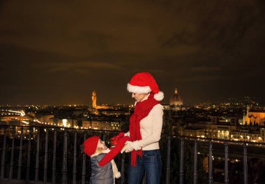Gezi Floransa'da Noel anda ilham dolu. genç anne ve kızı gezginler Floransa, İtalya oynarken Noel şapka ile gülümseyen