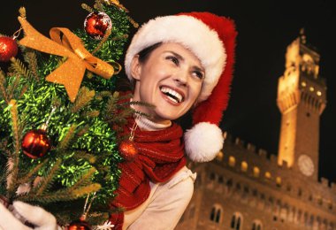 Gezi Floransa'da Noel anda ilham dolu. Noel ağacı mesafe içine arıyorum ile Floransa, İtalya Palazzo Vecchio önünde Noel şapkalı gülümseyen modern kadın portresi