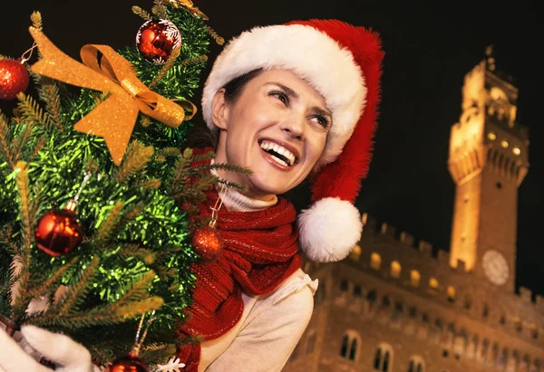Gezi Floransa'da Noel anda ilham dolu. Noel ağacı mesafe içine arıyorum ile Floransa, İtalya Palazzo Vecchio önünde Noel şapkalı gülümseyen modern kadın portresi