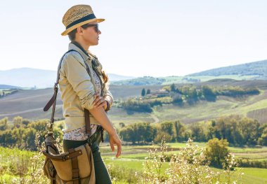 Tuscany büyülü manzarasını keşfetmek. mesafe içine bakarak sağlıklı kadın uzun yürüyüşe çıkan kimse Tuscany'de hiking bir çanta