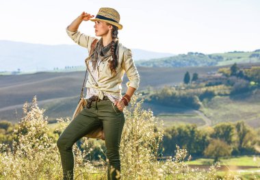 Tuscany büyülü manzarasını keşfetmek. mesafe içine bakarak sağlıklı kadın uzun yürüyüşe çıkan kimse Tuscany'de hiking bir çanta