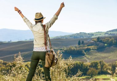 Tuscany büyülü manzarasını keşfetmek. Aktif kadın Tuscany sevinçli'da şapka yürüyüş uzun yürüyüşe çıkan kimse arkasından gördüm