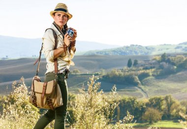 Tuscany büyülü manzarasını keşfetmek. Tuscany manzarayı vintage fotoğraf makinesi ile çanta ile aktif kadın uzun yürüyüşe çıkan kimse