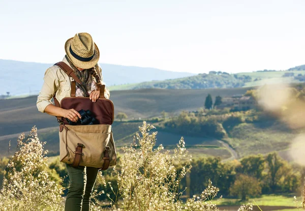 Tuscany büyülü manzarasını keşfetmek. Dürbün alarak genç kadın uzun yürüyüşe çıkan kimse Tuscany'de hiking bir çanta