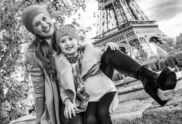 快乐的母亲和女儿在巴黎埃菲尔铁塔附近路堤上坐在栏杆上的旅行者 — 图库照片