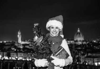 Gezi Floransa'da Noel anda ilham dolu. Piazzale Michelangelo Floransa, İtalya, Noel şapka Noel ağacı ve hediye ile gülümseyen genç kadın portresi