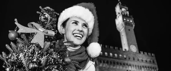 Gezi Floransa'da Noel anda ilham dolu. Noel ağacı mesafe içine arıyorum ile Floransa, İtalya Palazzo Vecchio önünde Noel şapkalı gülümseyen modern kadın portresi