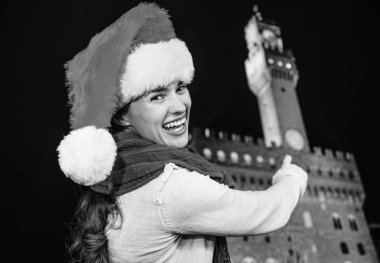 Gezi Floransa'da Noel anda ilham dolu. Gülümseyen Floransa, İtalya Palazzo Vecchio işaret içinde Noel şapkalı modern turist kadın portresi