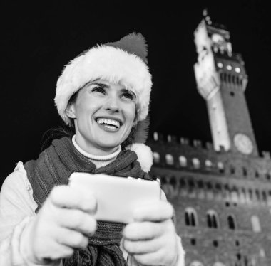 Gezi Floransa'da Noel anda ilham dolu. Palazzo Vecchio Floransa, İtalya sms yazma karşı Noel şapkalı gülümseyen genç kadın portresi