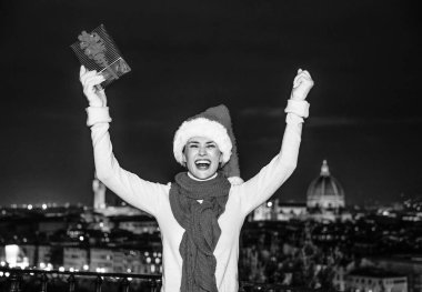 Gezi Floransa'da Noel anda ilham dolu. Piazzale Michelangelo Floransa, İtalya, Noel şapkasıyla Noel hediyesi kutusu mutluluk neşeli genç kadın portresi