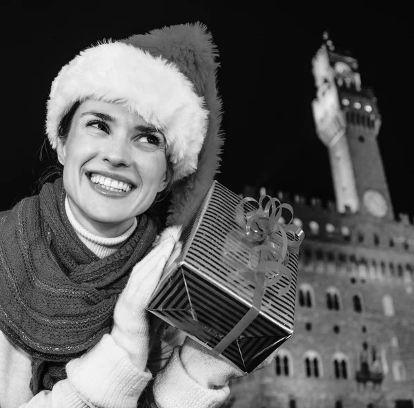 Gezi Floransa'da Noel anda ilham dolu. Noel hediyesi kutusunu sallayarak Noel şapka Floransa, İtalya mutlu modern kadın portresi