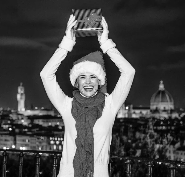 Gezi Floransa'da Noel anda ilham dolu. Noel hediye kutusu sevinçli Floransa panoramik ön tarafında Noel şapkalı gülümseyen genç kadın