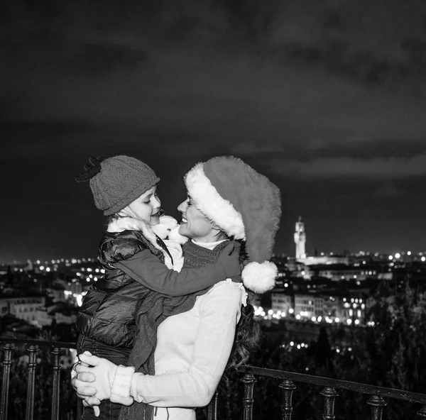 Gezi Floransa'da Noel anda ilham dolu. Modern anne ve çocuk gezginler ile Noel şapka Piazzale Michelangelo, Floransa, İtalya kucaklayan içinde gülümseyen