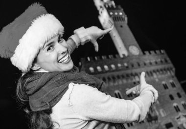 Gezi Floransa'da Noel anda ilham dolu. gülümseyen Floransa, İtalya çerçeveleme elle yapılan Palazzo Vecchio karşı Noel şapkalı modern kadın