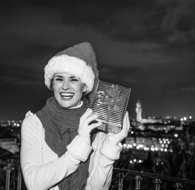 Gezi Floransa'da Noel anda ilham dolu. Noel hediyesi kutusunu sallayarak mutlu genç kadında Noel şapka Floransa, İtalya