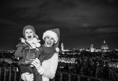 Gezi Floransa'da Noel anda ilham dolu. Modern anne ve çocuk turist Noel şapka panoramik Floransa gösteren Noel hediyesi kutusunun önünde gülümseyen portresi