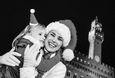 Gezi Floransa'da Noel anda ilham dolu. Genç Anne ve çocuk gezginler Floransa, İtalya sarılma içinde Noel şapka ile gülümseyen portresi