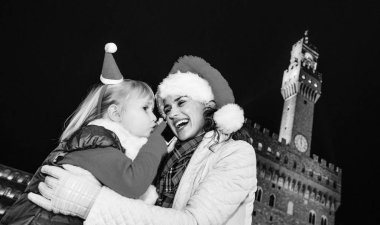 Gezi Floransa'da Noel anda ilham dolu. mutlu genç anne ve kızı gezginler Floransa, İtalya bir cep telefonu konuşurken Noel şapka ile