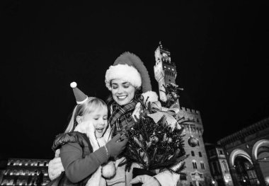 Gezi Floransa'da Noel anda ilham dolu. Modern anne ve Florence, İtalya çocuk gezginler ile Noel ağacı-Noel şapka Palazzo Vecchio karşı ile gülümseyen