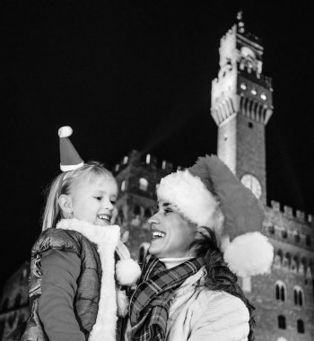 Gezi Floransa'da Noel anda ilham dolu. Modern anne ve kızı turist Noel şapka Palazzo Vecchio Floransa, İtalya birbirine bakarak önünde gülümseyen portresi