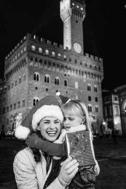 Gezi Floransa'da Noel anda ilham dolu. Floransa, İtalya Noel şapka Noel hediye kutusu ile mutlu genç anne ve çocuk turist portresi