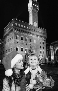 Gezi Floransa'da Noel anda ilham dolu. Noel şapka Palazzo Vecchio Floransa, İtalya ile Noel önünde mutlu modern anne ve çocuk turist kutusu sunmak
