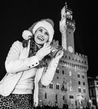 Gezi Floransa'da Noel anda ilham dolu. Palazzo Vecchio Floransa, İtalya için Noel hediyesi kutusunu sallayarak önünde mutlu modern kadın