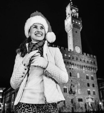 Gezi Floransa'da Noel anda ilham dolu. Palazzo Vecchio Floransa, İtalya mesafe içine bakarak karşı Noel şapkalı gülümseyen genç kadın