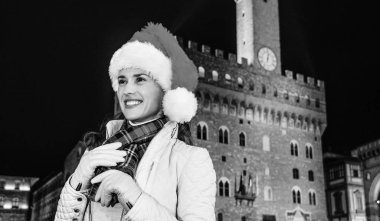 Gezi Floransa'da Noel anda ilham dolu. Palazzo Vecchio Floransa, İtalya mesafe içine bakarak önünde Noel şapkalı gülümseyen genç kadın