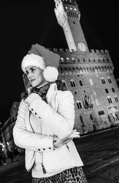 Gezi Floransa'da Noel anda ilham dolu. mesafe içine arayan dalgın genç kadın Noel şapkalı Floransa, İtalya